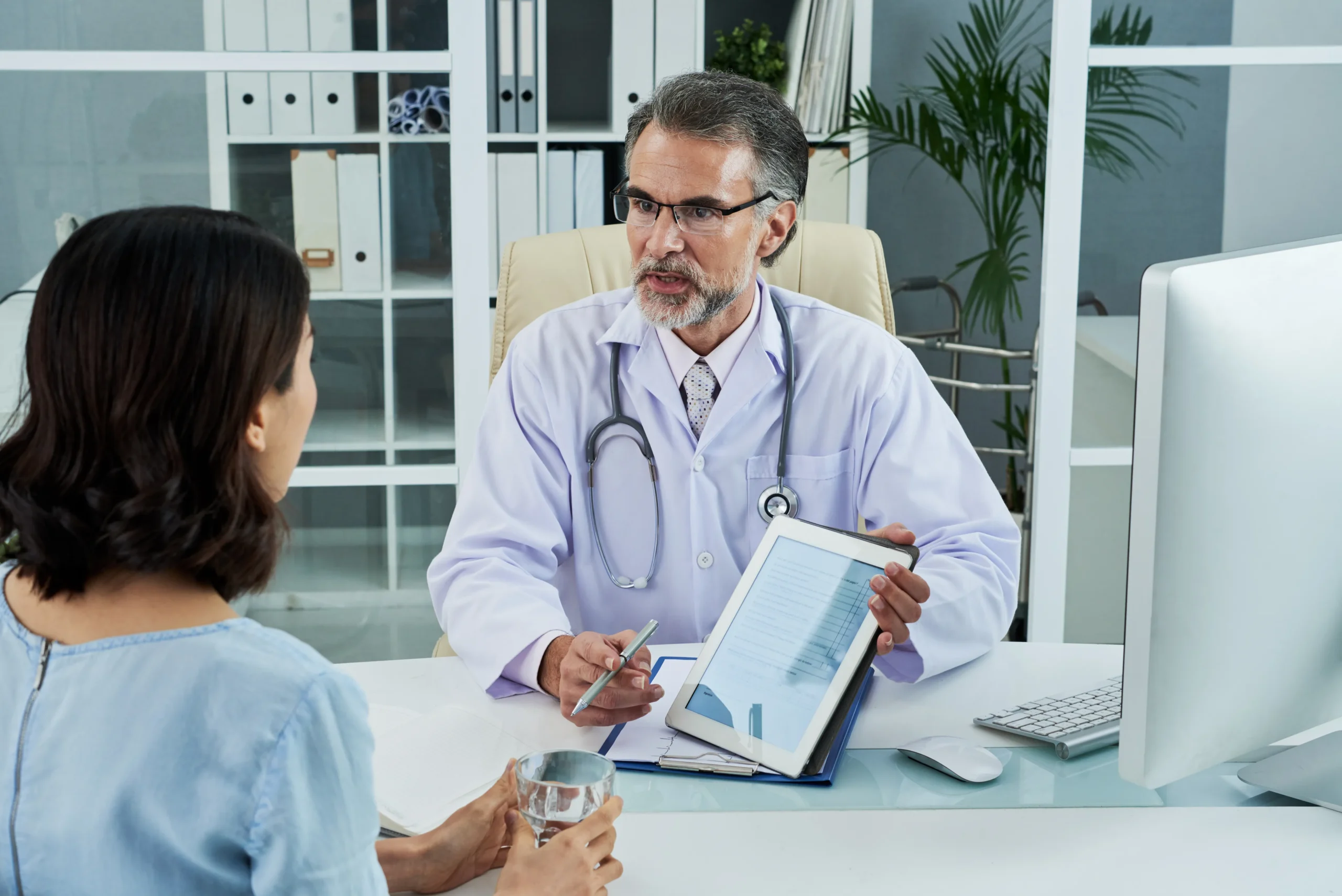 Primary care physicians managing electronic medical health history records on a laptop.